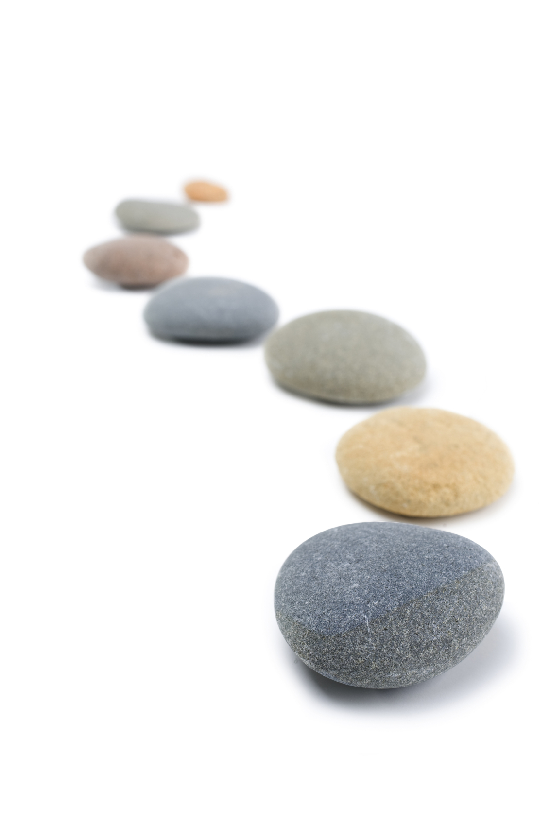 Rounded stones arranged in a curving line on white background. More stones:-[url=http://www.istockphoto.com/file_search.php?action=file&lightboxID=4053403]here[/url]